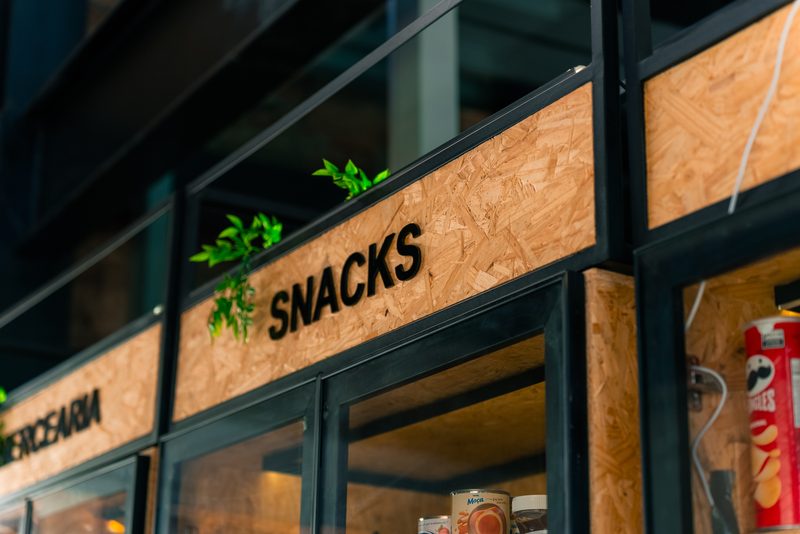 Sinalizacao em relevo com a palavra Snacks sobre painel de madeira