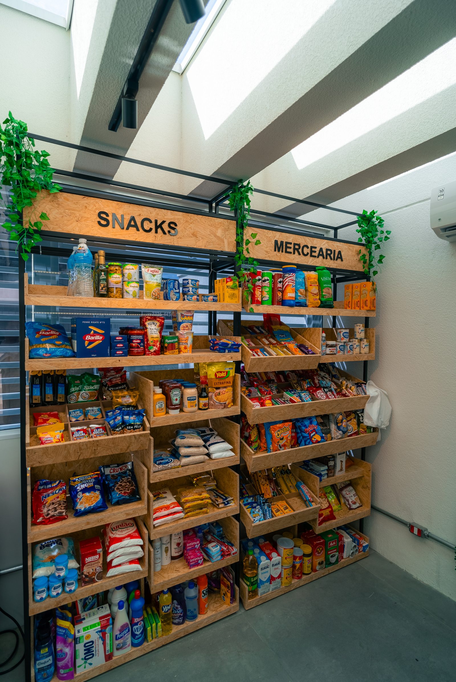 Gôndolas de madeira OSB com mercearia, massas, molhos e snacks organizados por categoria